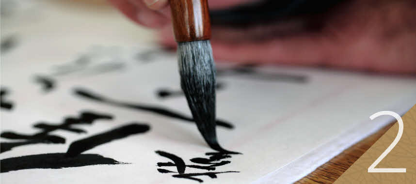 Person off-screen engaging in Chinese calligraphy writing as a metaphor to start now.