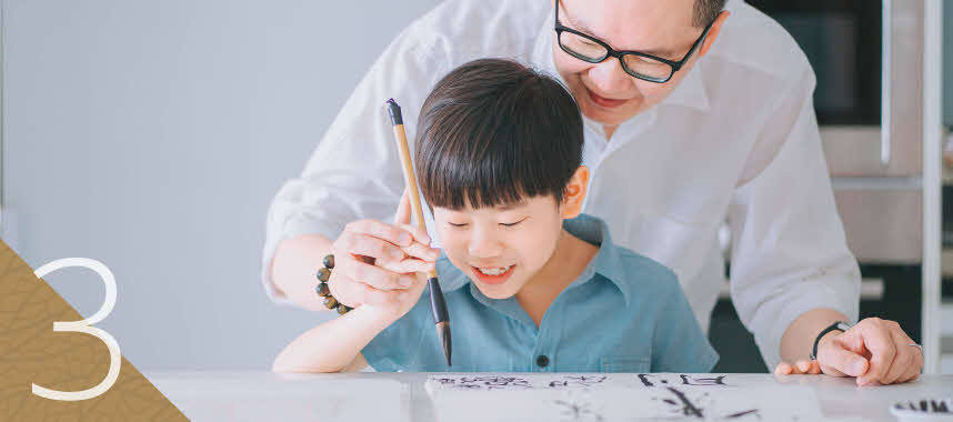 Father and son practising calligraphy together, to show that there’s a right place for legacy planning.