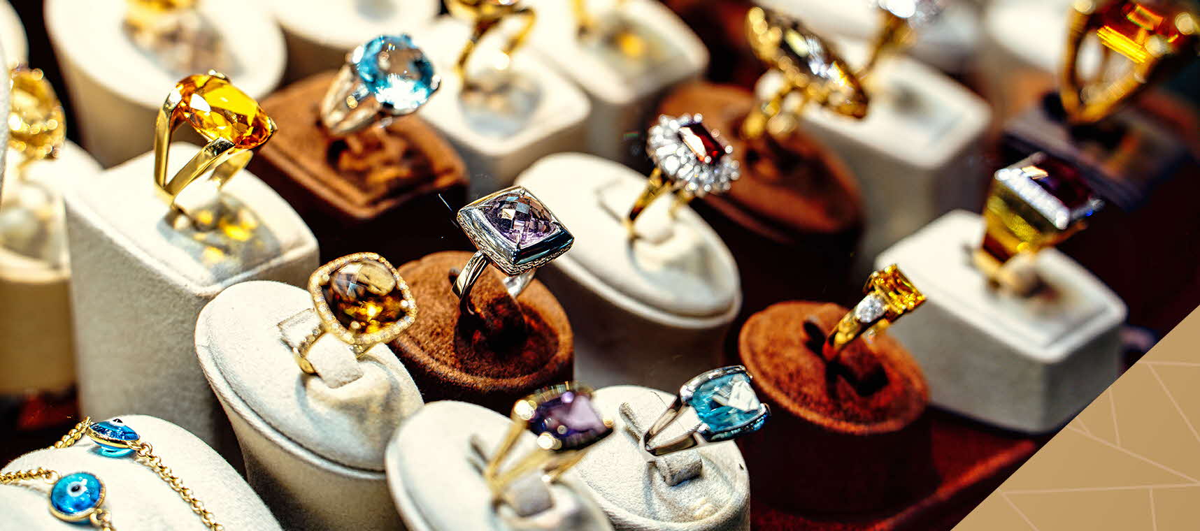 Various precious stone rings being displayed alongside one another. 